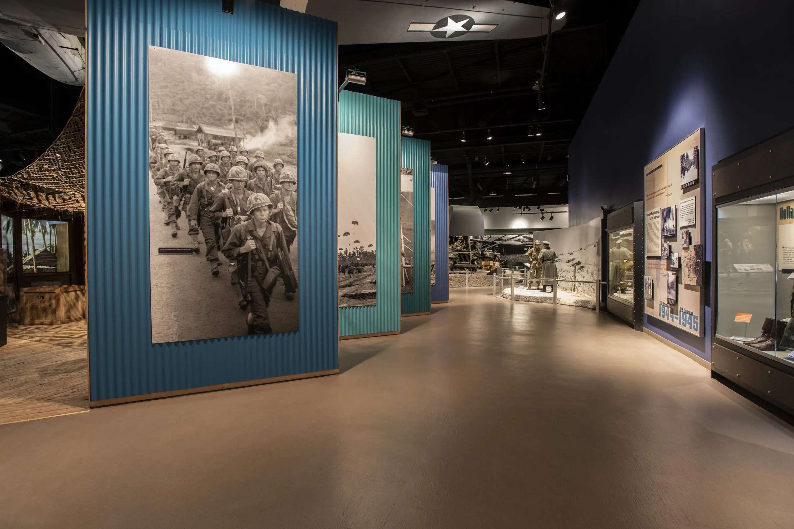 Museum gallery with large historical photographs and immersive military exhibits