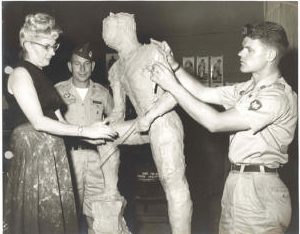 Leah Hiebert and Specialist Janis Krisans shaping a clay model as Major Earl Peterson observes