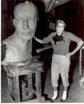 Leah Hiebert standing beside the finished clay model of the statue's head