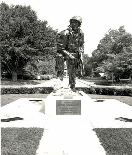 Iron Mike standing on its plaza with the honor plaque visible at its base