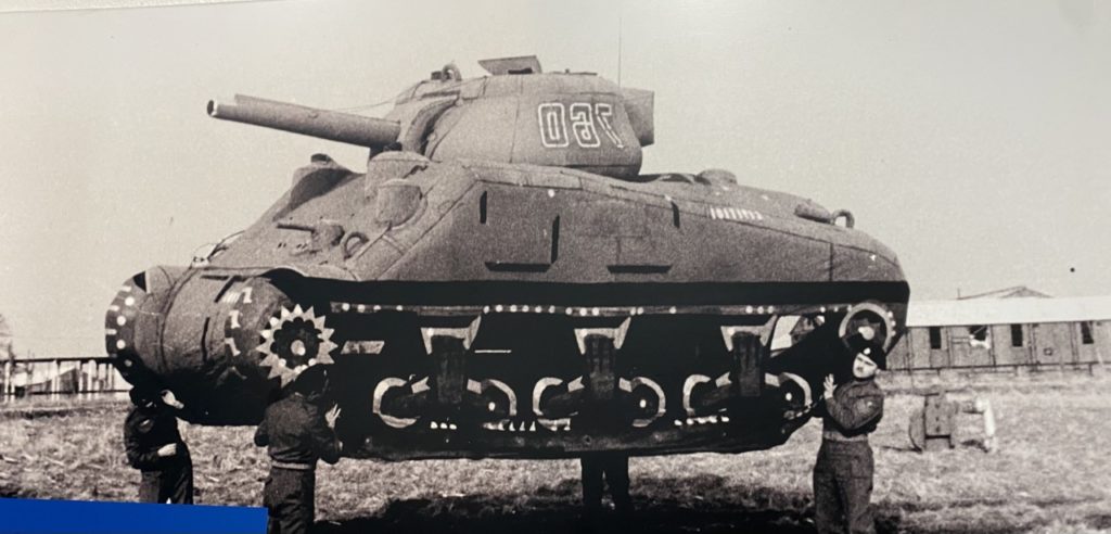 Ghost Army Soldiers lifting an inflatable tank. Built on a frame of inflatable tubes, the facsimiles were surprisingly realistic when viewed from a few hundred yards, from a reconnaissance plane in the air, and especially when combined with camouflage netting or other natural coverage.