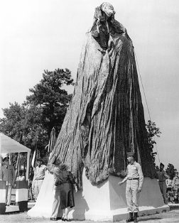 The statue standing draped in a parachute cover before the unveiling ceremony